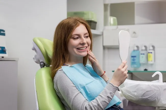 Dentist examining girl's teeth in clinic after a Dental Treatment